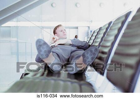 Businessman relaxing in airport lounge View Large Photo Image Picture - Businessman relaxing in airport lounge. Fotosearch