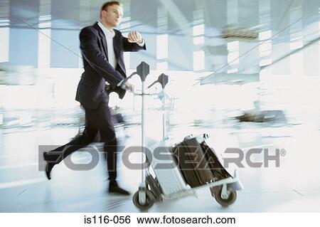 Businessman rushing in airport terminal View Large Photo Image Stock Photograph - Businessman rushing in airport terminal. Fotosearch