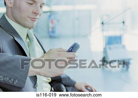 Stock Photo - Businessman with cellphone at airport . Fotosearch