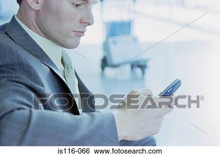Businessman with cellphone at airport View Large Photo Image Stock Photograph - Businessman with cellphone at airport . Fotosearch