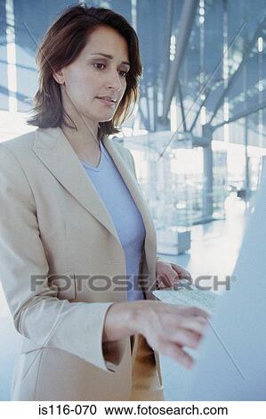 Stock Image - Businesswoman checking airline ticket. Fotosearch