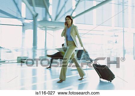 Stock Photo - Businesswoman in airport terminal. Fotosearch