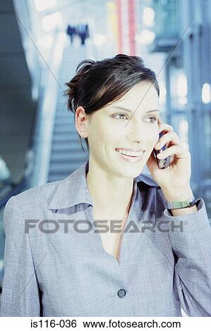 Stock Photograph - Businesswoman with cellphone at airport . Fotosearch