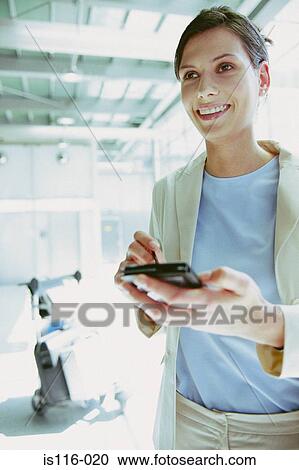 Businesswoman with palmtop at airport View Large Photo Image Stock Image - Businesswoman with palmtop at airport . Fotosearch