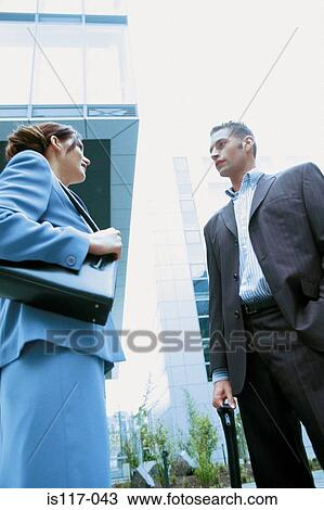 Businessman and businesswoman talking outside office View Large Photo Image Stock Image - Businessman and businesswoman talking outside office. Fotosearch