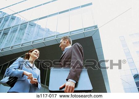 Businessman and businesswoman talking outside office View Large Photo Image Stock Photo - Businessman and businesswoman talking outside office. Fotosearch