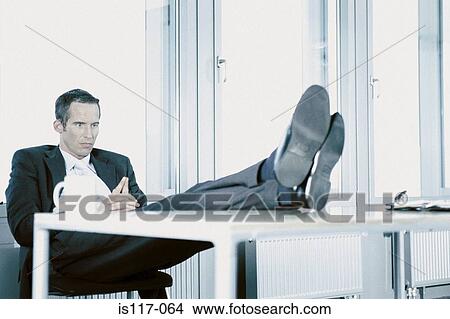 Businessman relaxing in office View Large Photo Image Picture - Businessman relaxing in office. Fotosearch