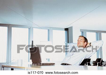 Stock Image - Businessman relaxing in office. Fotosearch