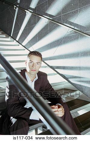 Businessman sitting on modern stairway View Large Photo Image Picture - Businessman sitting on modern stairway. Fotosearch