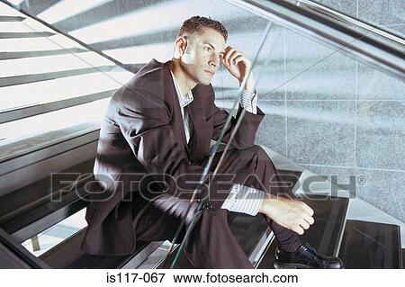 Businessman sitting on modern stairway View Large Photo Image Stock Photo - Businessman sitting on modern stairway. Fotosearch
