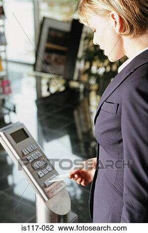 Stock Image - Businesswoman entering security pass. Fotosearch