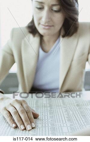 Picture - Businesswoman reading stocks and shares. Fotosearch
