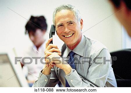 Stock Photo - Businessman on telephone in office. Fotosearch