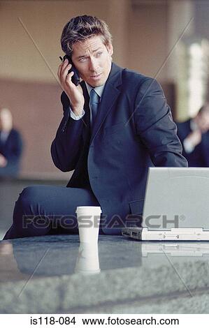 Picture - Businessman outside with laptop and cellphone. Fotosearch