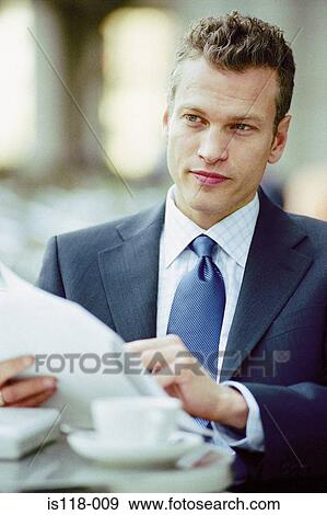 Businessman reading at a cafe View Large Photo Image Stock Photo - Businessman reading at a cafe. Fotosearch