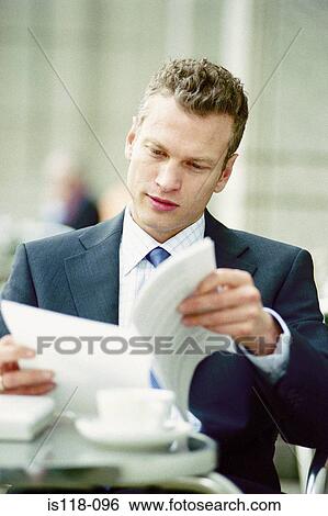 Stock Photograph - Businessman reading at a cafe. Fotosearch