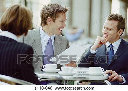 Stock Photograph - Businesspeople having meeting at cafe. Fotosearch
