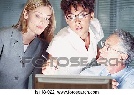 Stock Image - Businesspeople looking at computer screen. Fotosearch