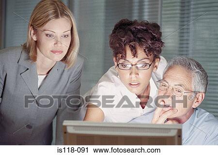 Businesspeople looking at computer screen View Large Photo Image Stock Image - Businesspeople looking at computer screen. Fotosearch