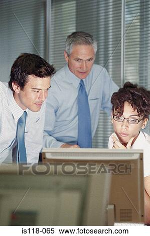 Businesspeople looking at computer screen View Large Photo Image Stock Photography - Businesspeople looking at computer screen. Fotosearch