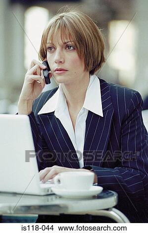 Businesswoman with laptop and cellphone at a cafe View Large Photo Image Picture - Businesswoman with laptop and cellphone at a cafe. Fotosearch
