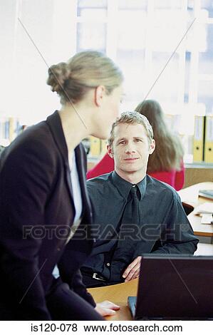 Businessman and businesswoman using laptop in office View Large Photo Image Stock Photo - Businessman and businesswoman using laptop in office. Fotosearch