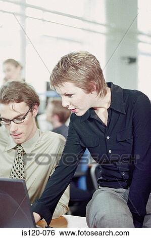 Businessman and businesswoman using laptop in office View Large Photo Image Stock Photograph - Businessman and businesswoman using laptop in office. Fotosearch
