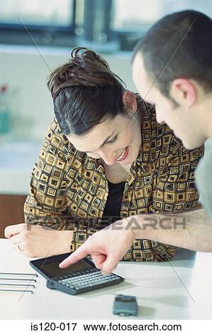 Man and woman using personal organiser View Large Photo Image Stock Photo - Man and woman using personal organiser. Fotosearch
