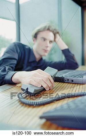 Man on laptop and telephone at home View Large Photo Image Stock Image - Man on laptop and telephone at home. Fotosearch