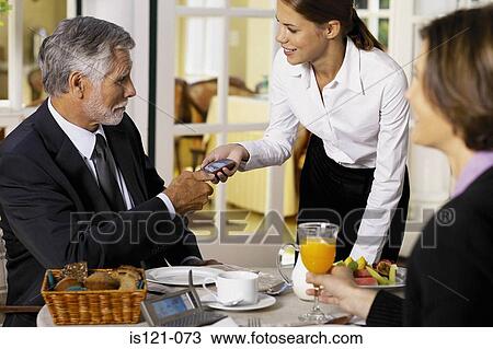 Stock Image - Businessman and businesswoman having breakfast. Fotosearch