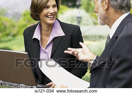 Businessman and businesswoman in a meeting outside View Large Photo Image Picture - Businessman and businesswoman in a meeting outside. Fotosearch