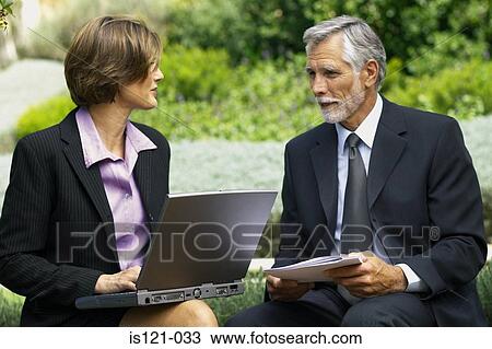 Businessman and businesswoman in a meeting outside View Large Photo Image Stock Image - Businessman and businesswoman in a meeting outside. Fotosearch