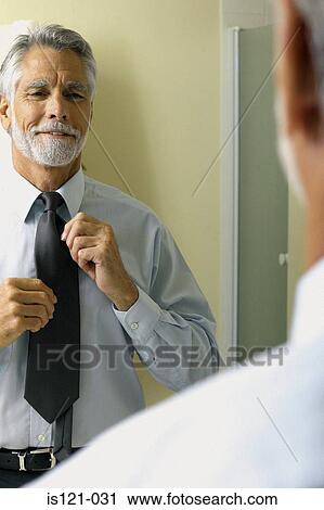Businessman arranging tie View Large Photo Image Stock Image - Businessman arranging tie. Fotosearch