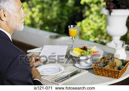 Stock Image - Businessman having breakfast. Fotosearch