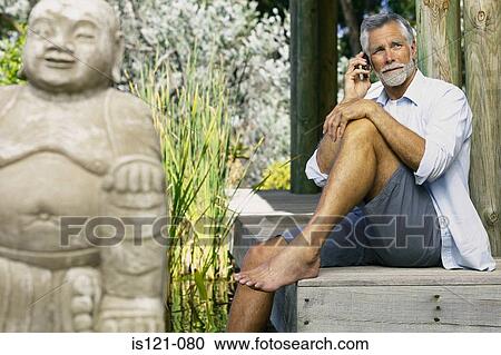 Man beside pool and buddha with cellphone View Large Photo Image Stock Image - Man beside pool and buddha with cellphone. Fotosearch