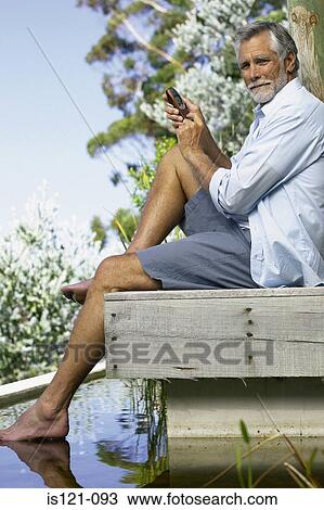 Man beside pool with cellphone View Large Photo Image Stock Image - Man beside pool with cellphone. Fotosearch