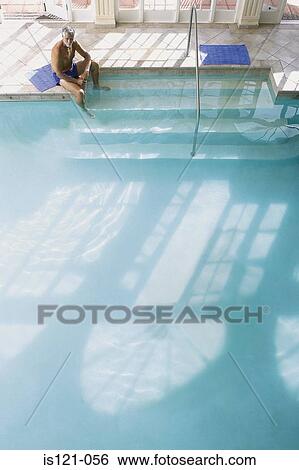 Stock Photograph - Man on the edge of swimming pool. Fotosearch
