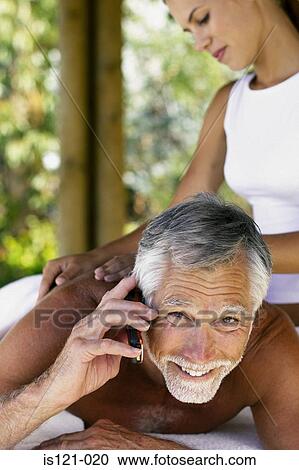 Man with cellphone being massaged View Large Photo Image Stock Image - Man with cellphone being massaged. Fotosearch
