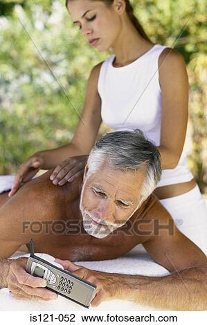 Man with cellphone being massaged View Large Photo Image Stock Image - Man with cellphone being massaged. Fotosearch