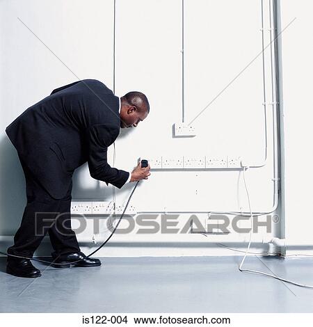 A Man plugging something in View Large Photo Image Picture - A Man plugging something in . Fotosearch