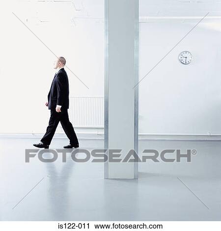A man walking through an open plan office View Large Photo Image Stock Image - A man walking through an open plan office. Fotosearch