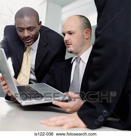 Stock Photograph - Two businessmen fascinated with a laptop . Fotosearch