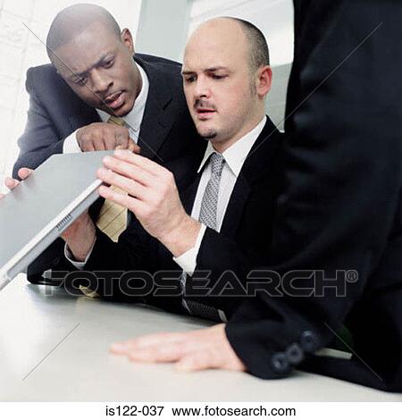 Two businessmen fixing a computer View Large Photo Image Stock Photo - Two businessmen fixing a computer. Fotosearch