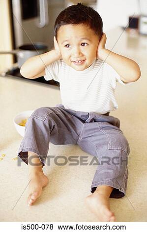 Stock Photo - Boy with hands over ears. Fotosearch