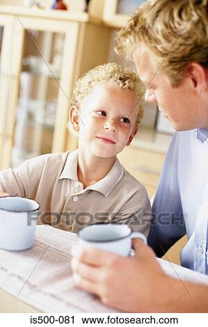 Stock Image - Father and son having a drink. Fotosearch