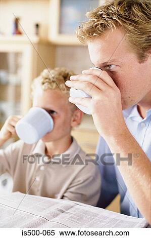 Stock Photography - Father and son having a drink. Fotosearch