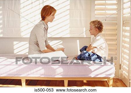 Stock Image - Mother and son on bed. Fotosearch