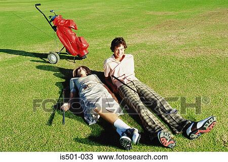 Stock Image - Man and woman playing golf. Fotosearch