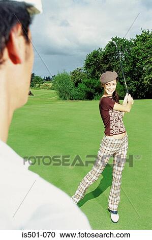 Stock Image - Man and woman playing golf. Fotosearch