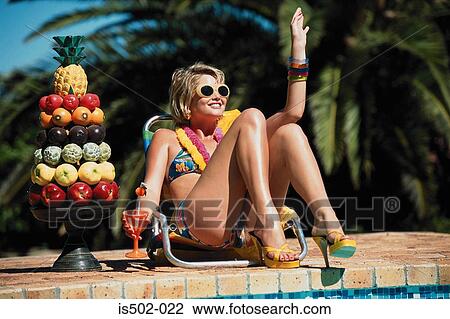 Stock Image - Fruit and sunbathing by the pool. Fotosearch